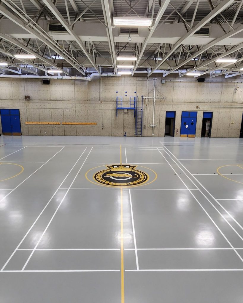 Epoxy flooring with line painting and brand logo in Calgary gym.